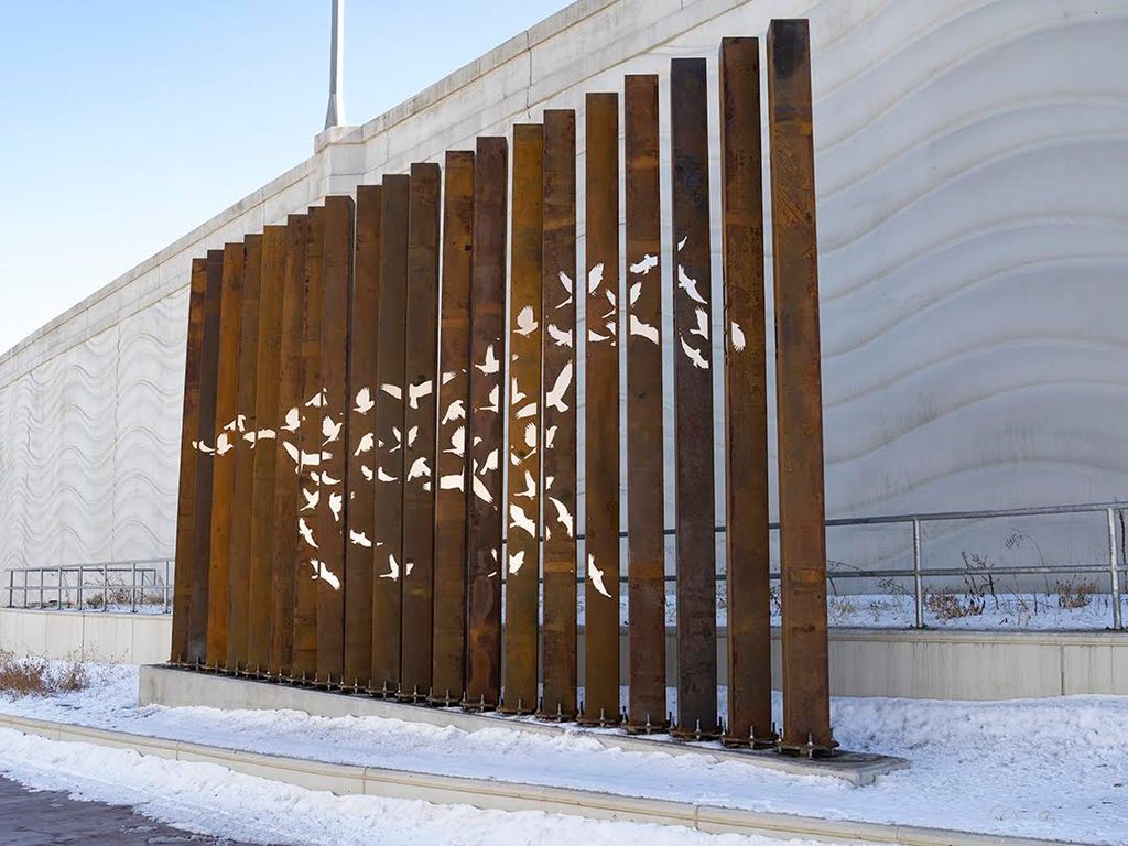 The sculpture is made of twenty, sixteen-foot-high Corten weathering steel columns, spanning approximately thirty-three feet, with stainless steel inserts, and will be lit externally.