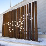 The sculpture is made of twenty, sixteen-foot-high Corten weathering steel columns, spanning approximately thirty-three feet, with stainless steel inserts, and will be lit externally.