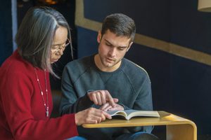 Student and faculty member reading