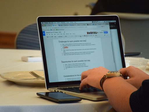 person types in collaborative Google Doc at conference table