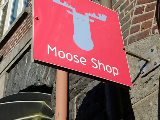 red sign with moose head shape and text 
