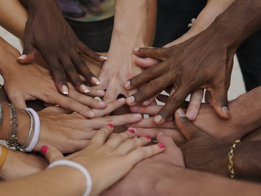 Many hands together: group of diverse people joining hands