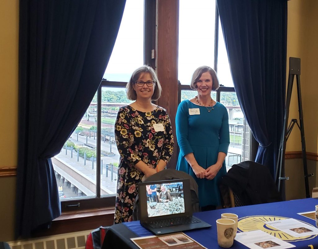 Professor of History Susannah Ottaway and alum Jess Bellville '00 at the Minnesota Humanities Center "Veterans' Voices Awards" 2019. They are standing in front of a table with a window behind them.