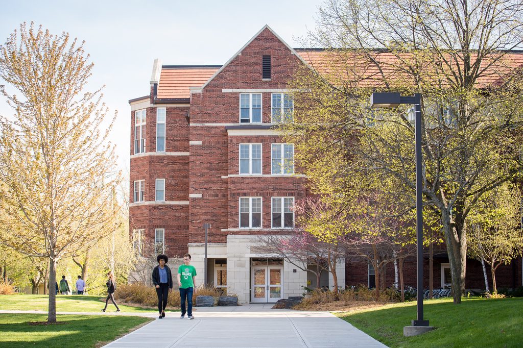 Two students walk past a dorm on the east side of the Carleton campus