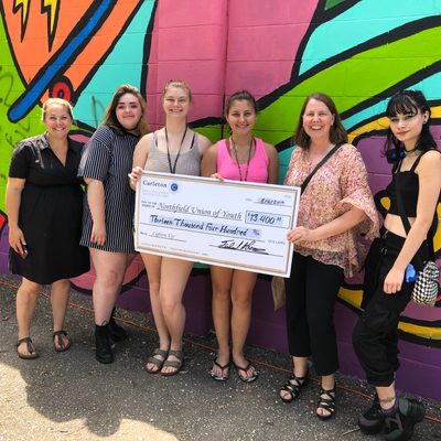 Carleton presents a check for $13,400 to the Northfield Union of Youth