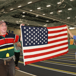 Two staff members displaying/carrying the American flag