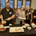 Five people gathered around a table displaying the food they prepared in the class.