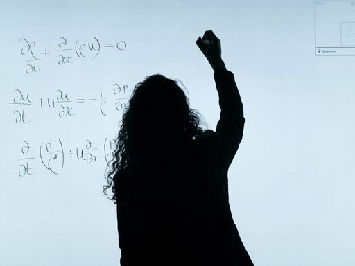 Woman writing formula on whiteboard