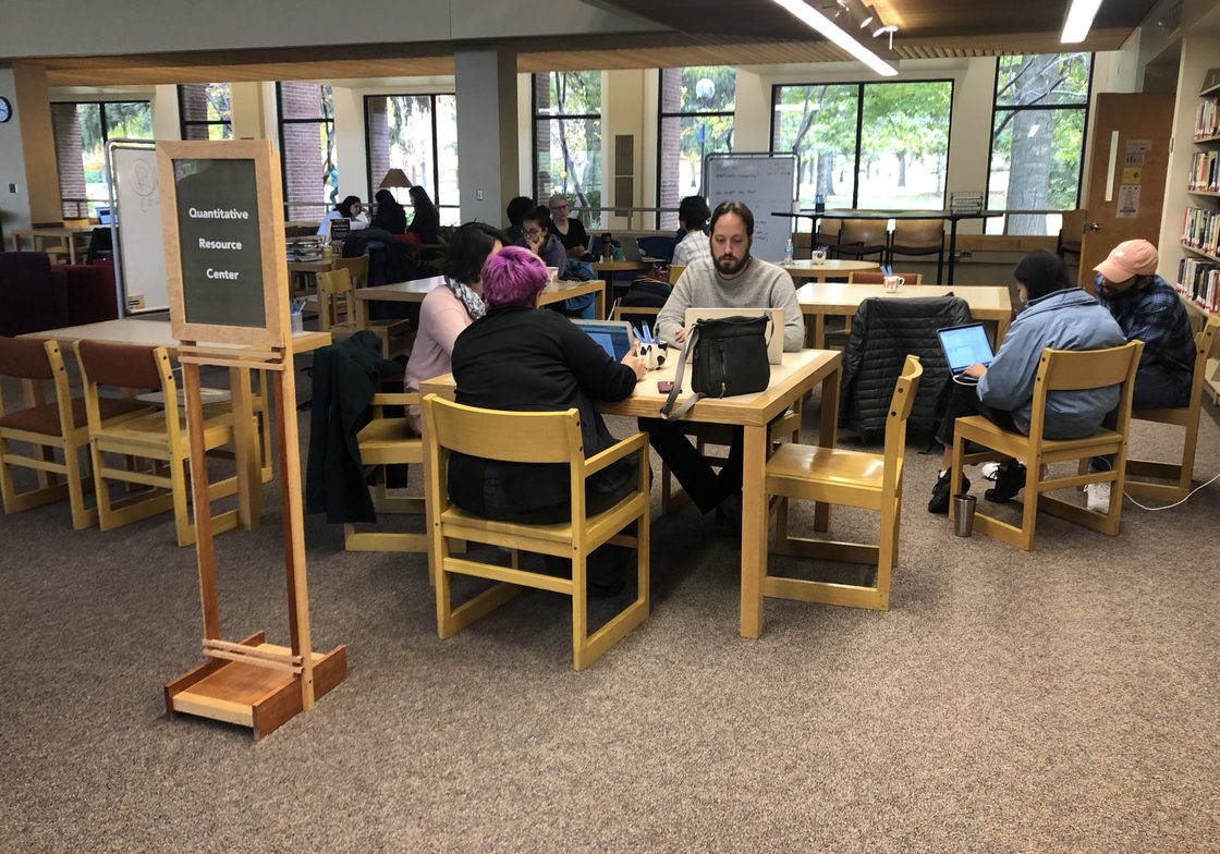 students gather at a library table