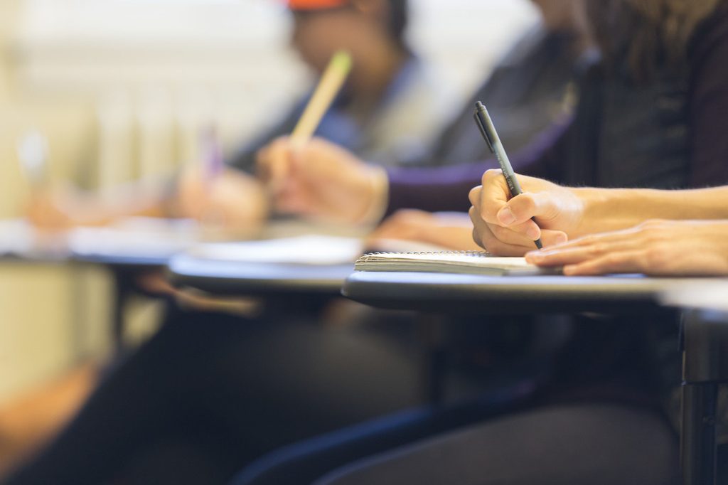 Students writing on pads of paper