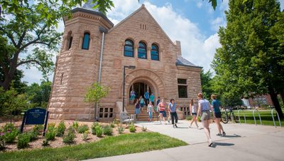 A campus tour group heading out of Scoville Hall on a sunny day