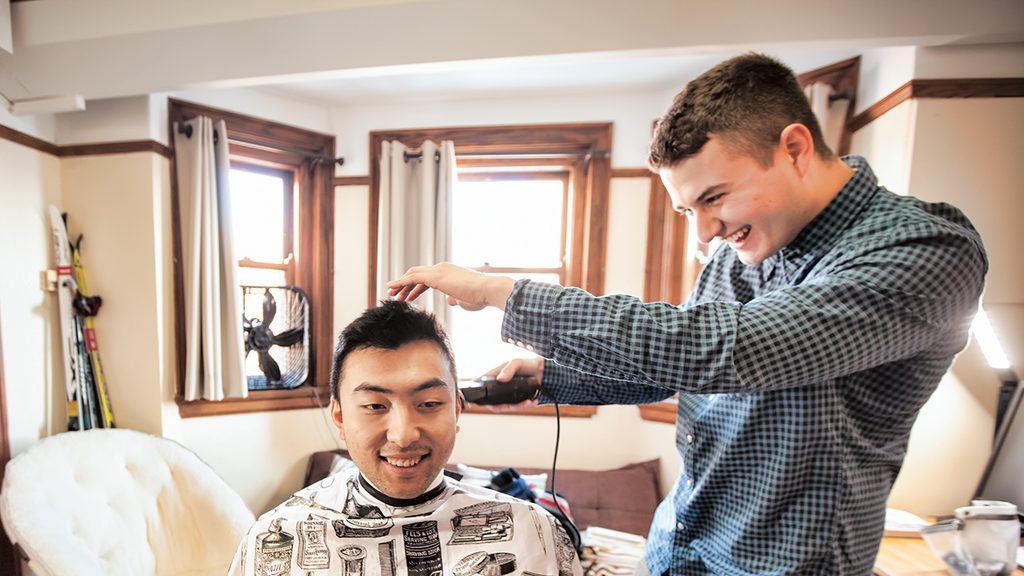 Junior Simon Orlovsky cuts a fellow student's hair in their dorm room