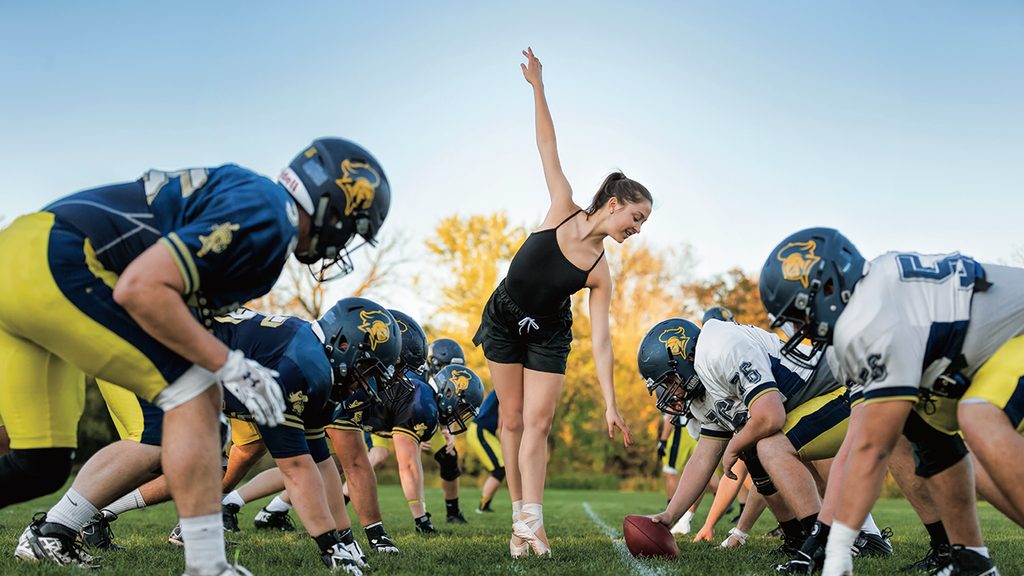 Carolyn Friedhoff performs ballet between the lines during a football scrimmage