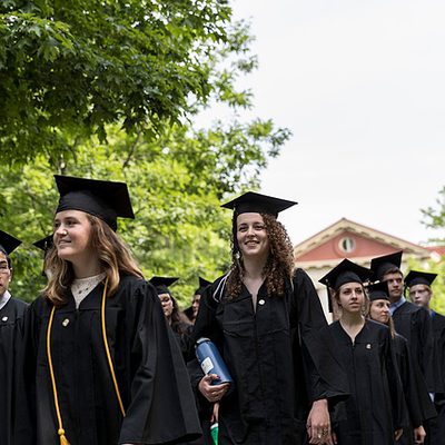 Students in caps and gowns process towards commencement