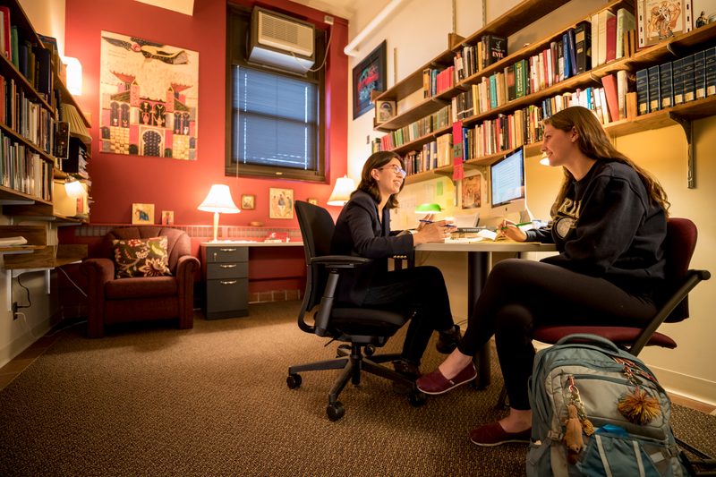 Two people have a conversation in an office