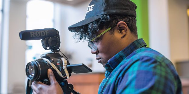 Filmmaker Brit Fryer ’15 adjusts his video camera