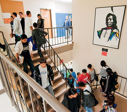 Students pass by a portrait of the school's namesake.