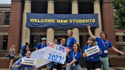 photo of students and "welcome new students" banner outside sayles