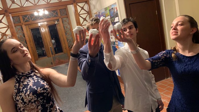 A group of Lucas' friends dramatically holding up snowballs in a semi-circle