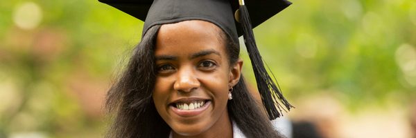 A young woman holds her diploma at commencement