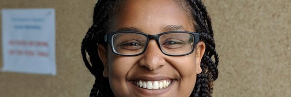 A smiling young woman wearing glasses