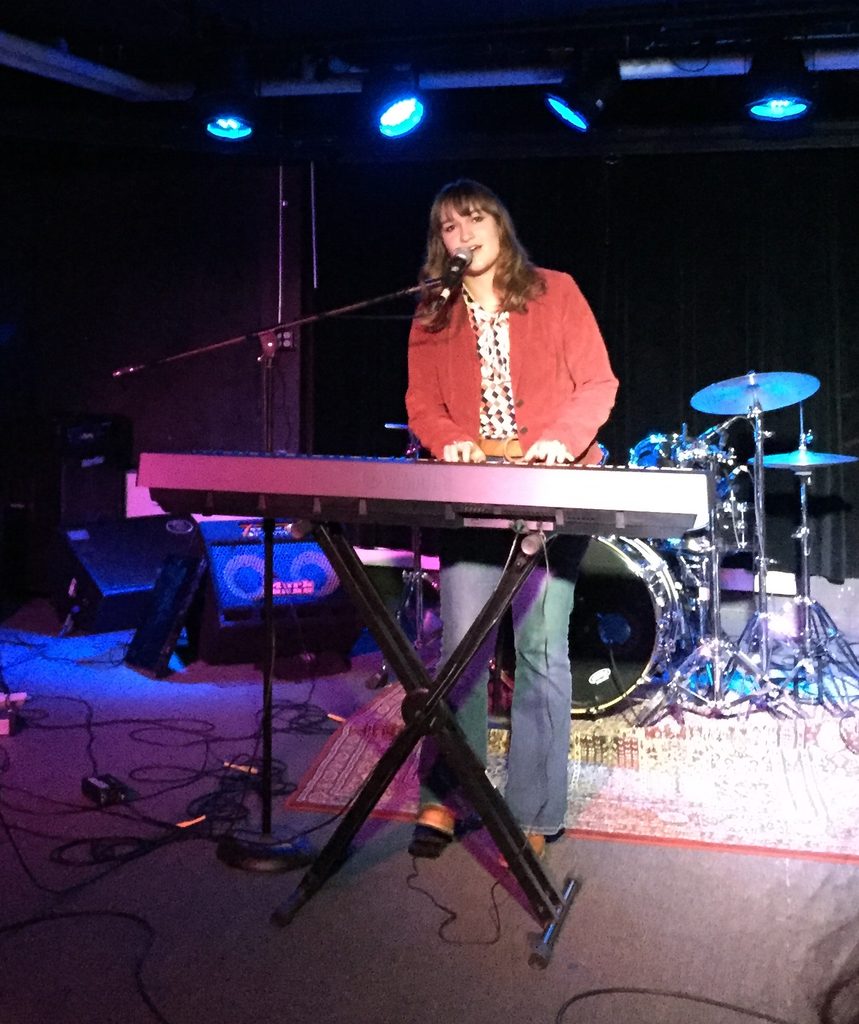 girl singing and playing piano