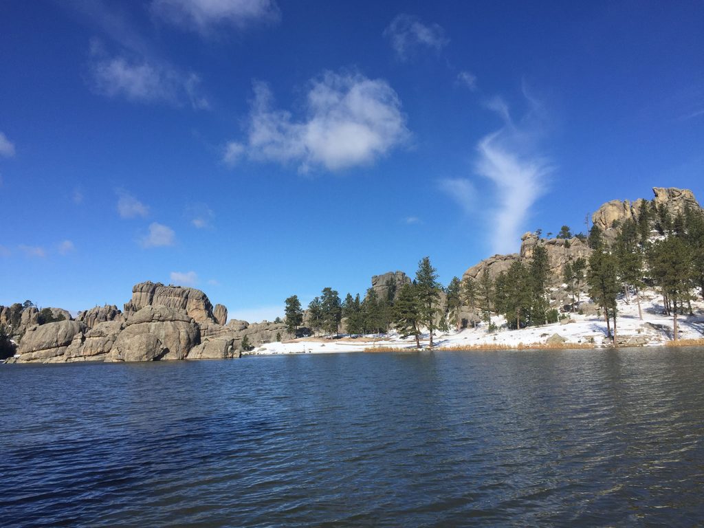 boulders and pines surrounding a blue lake