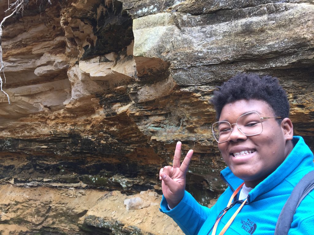 person with peace sign and rocks