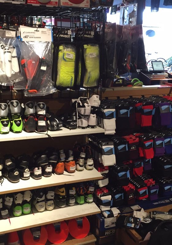 A shelf of soccer shoes and other soccer-related items in a store