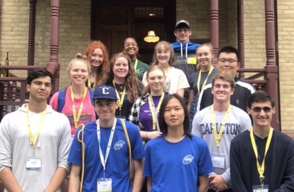 Group picture of 14 young adults in front of a beautiful house