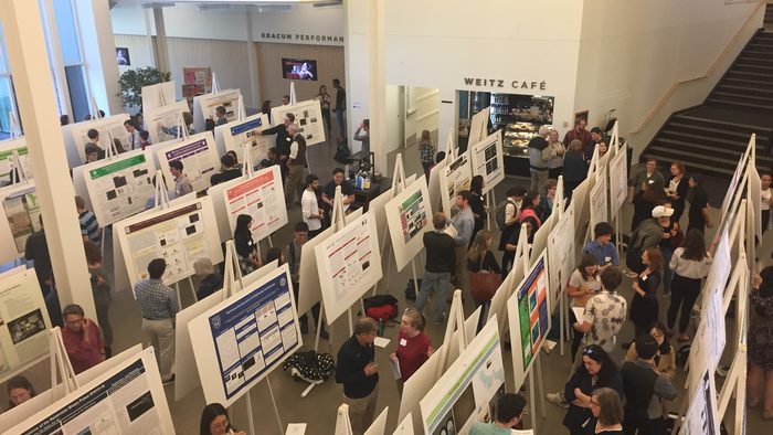 A room of student presenting their research posters in the Weitz commons