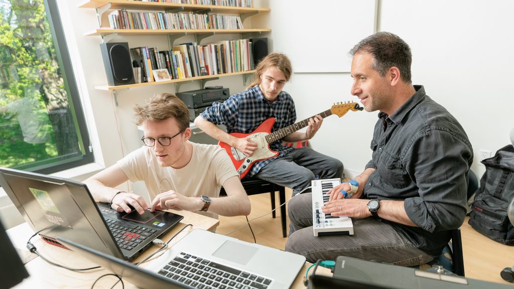students work on a composition with a professor