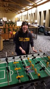 A Carl laughs while playing foosball in Sayles.