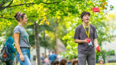 A student enjoys another student's juggling.