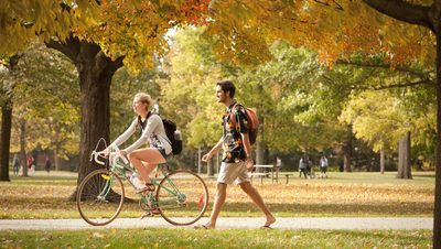 Two students walking by the Bald Spot in the fall