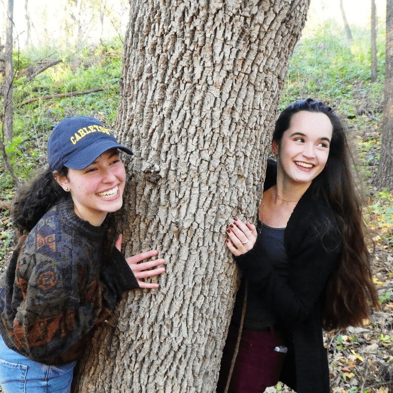 McKenna and her roommate peeking out from behind a tree