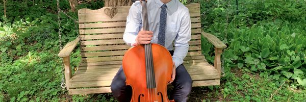 A picture of student Ewan Miller holding a cello