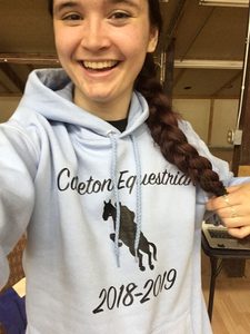 McKenna posing with her Carleton Equestrian hoodie