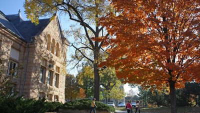 A photo of fall-colored trees in front of Carleton's Admissions building, Scoville Halle