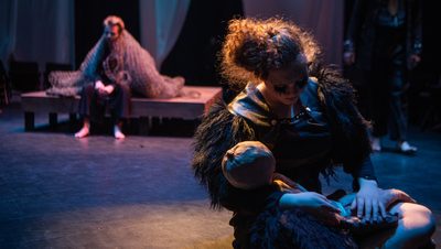 An actor cradling a doll in the Theater and Dance Department's production of That Wilderness of Glass