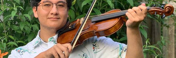 A photo of Tim Chiu holding a violin