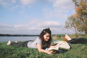 A student reading by a river