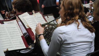 Close up of a horn player during a symphony band performance