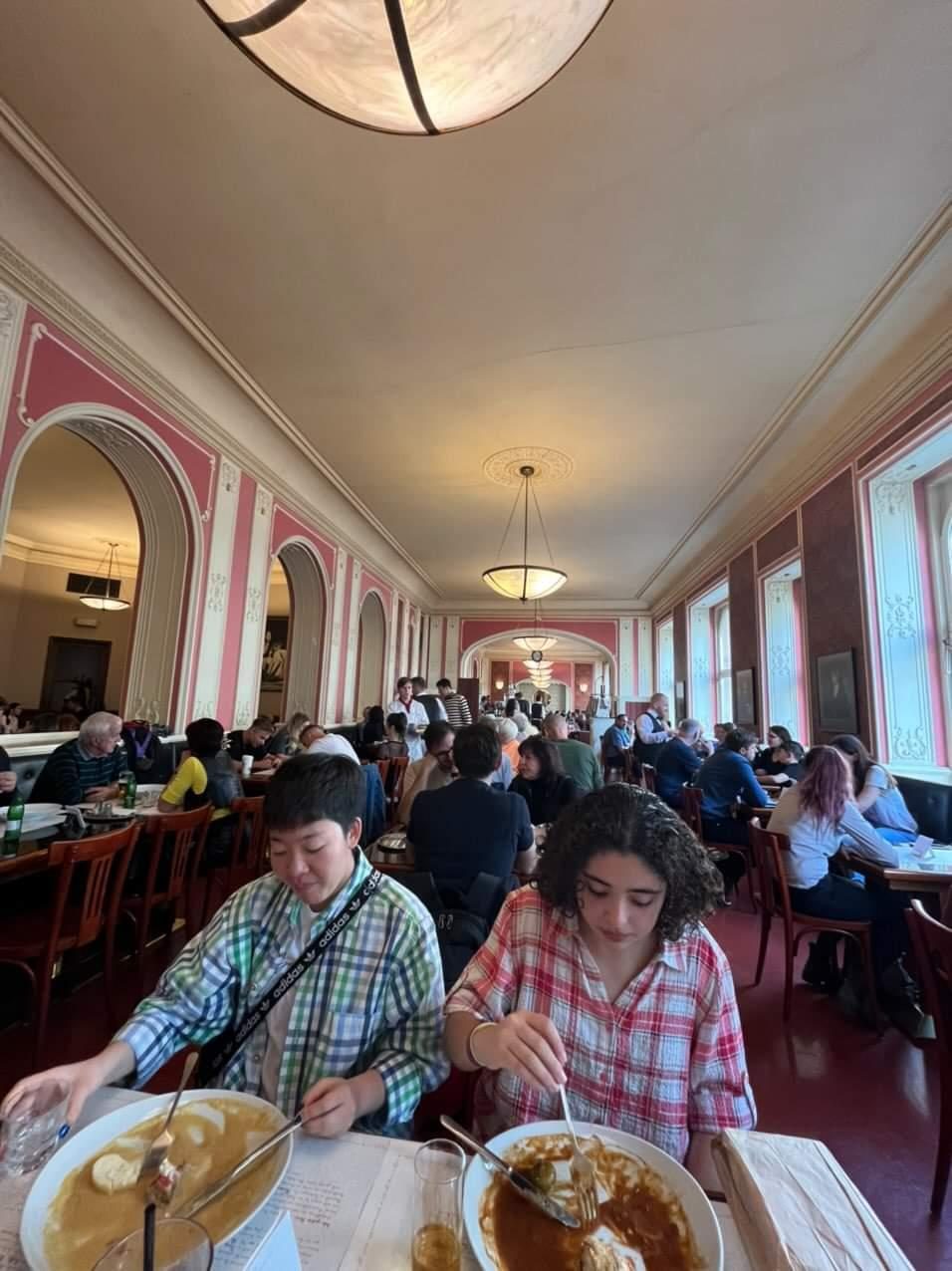 Students eating at a large restaurant.