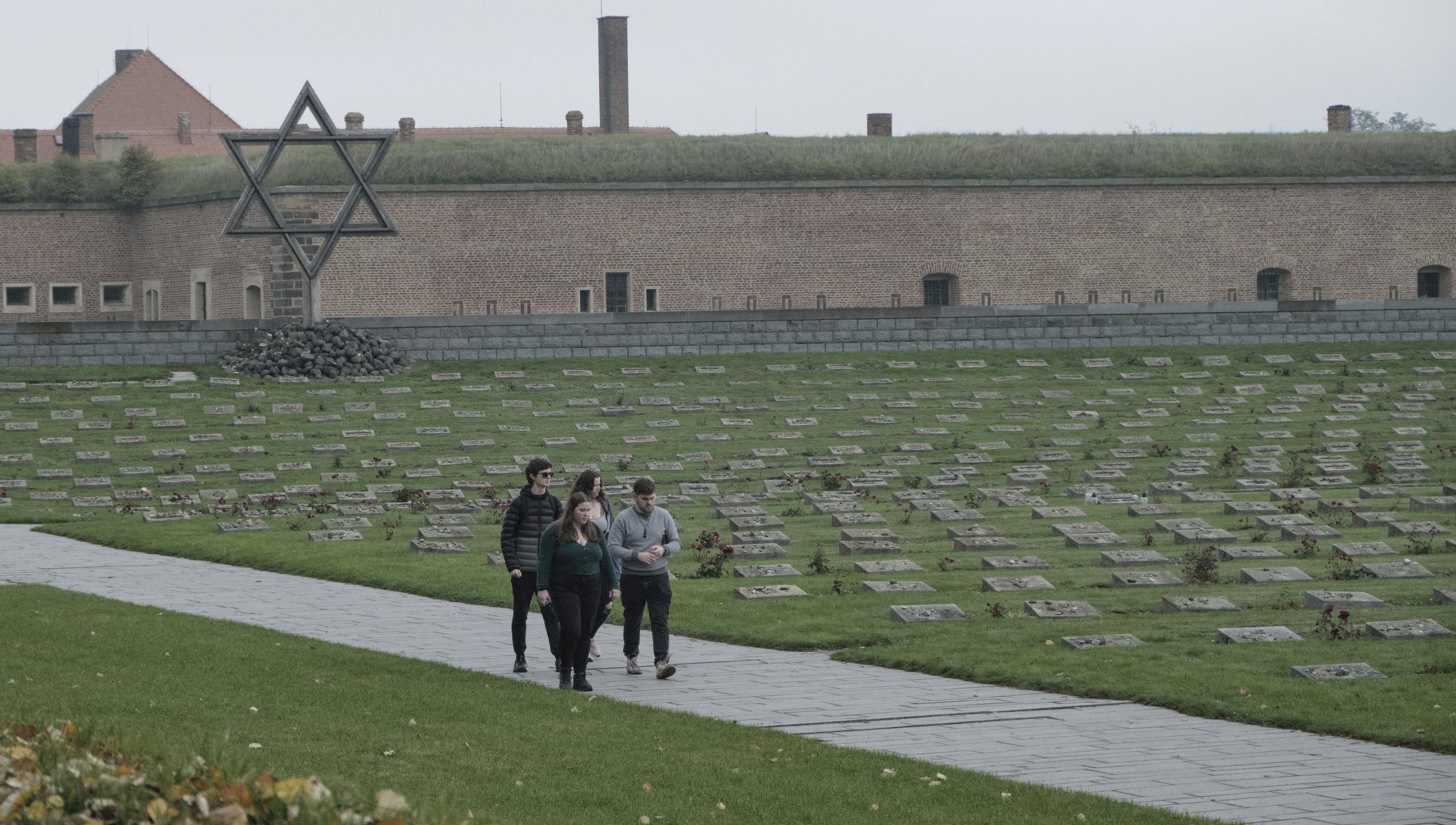Students walk in a cementery for Jews, in Terezín.