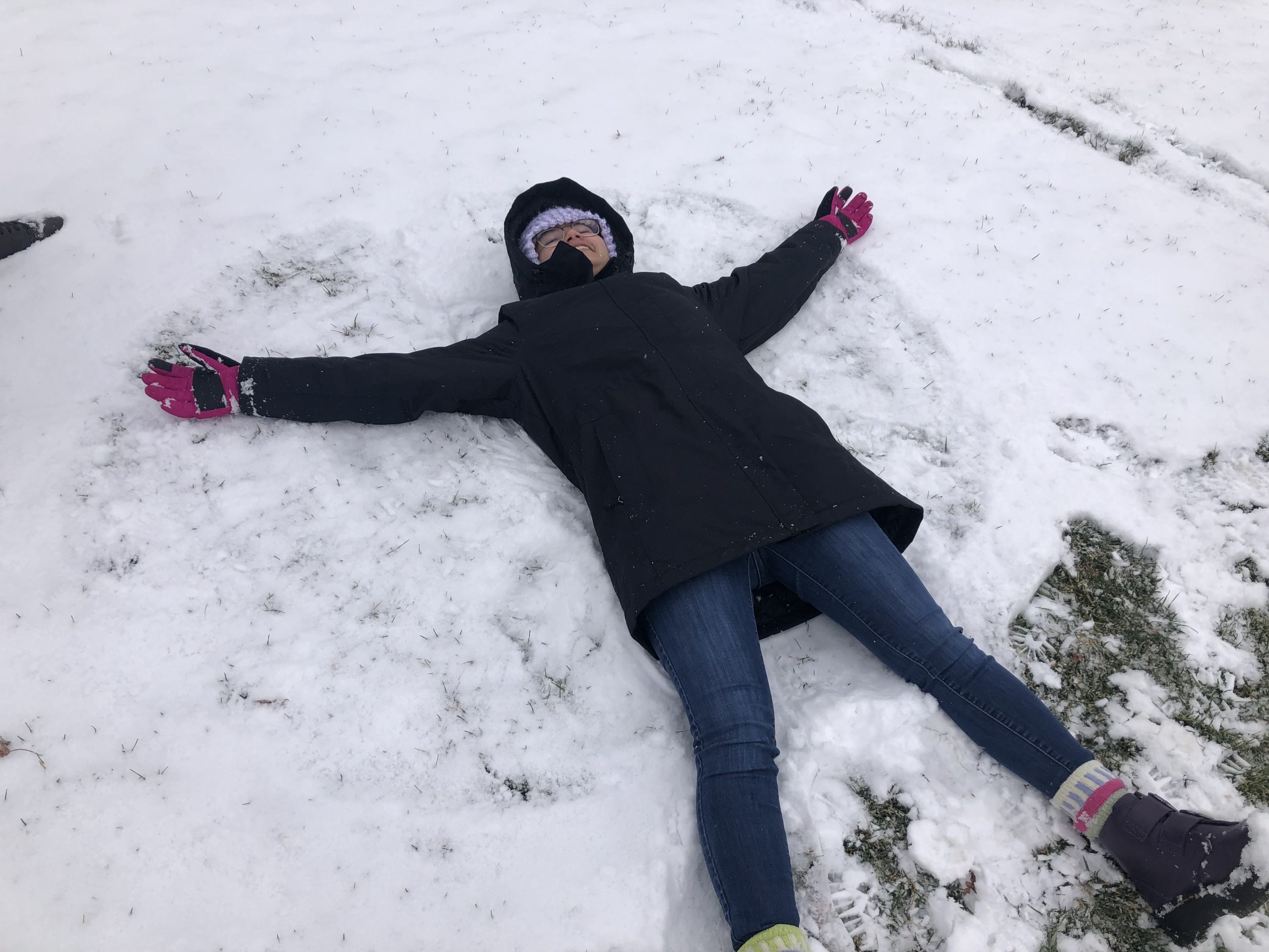 Student lays in the snow