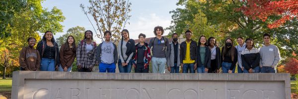 students posing next to Carleton sign