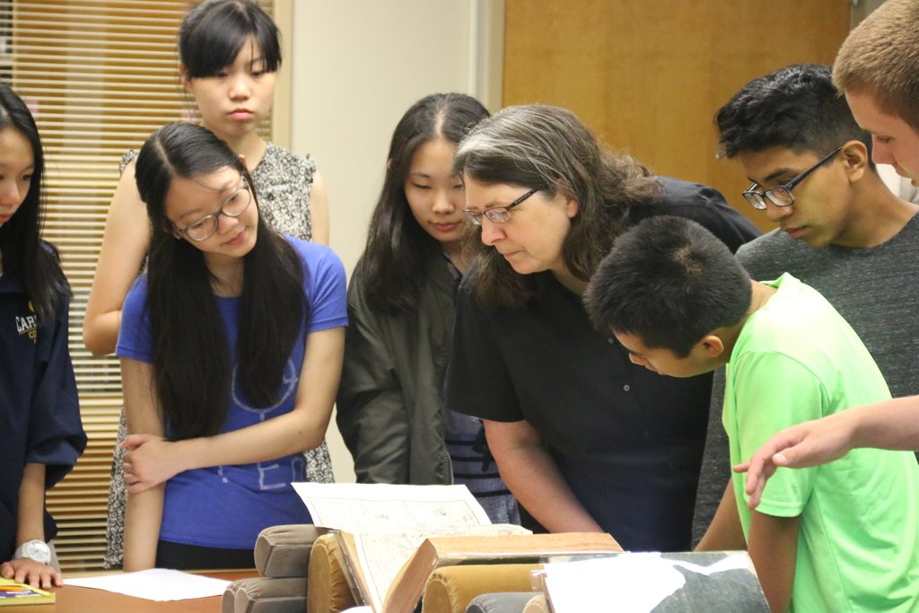 Humanities students looking at maps