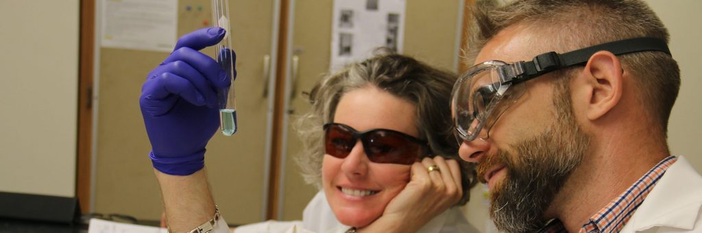 APSI science participants examining solution in a test tube with goggles on