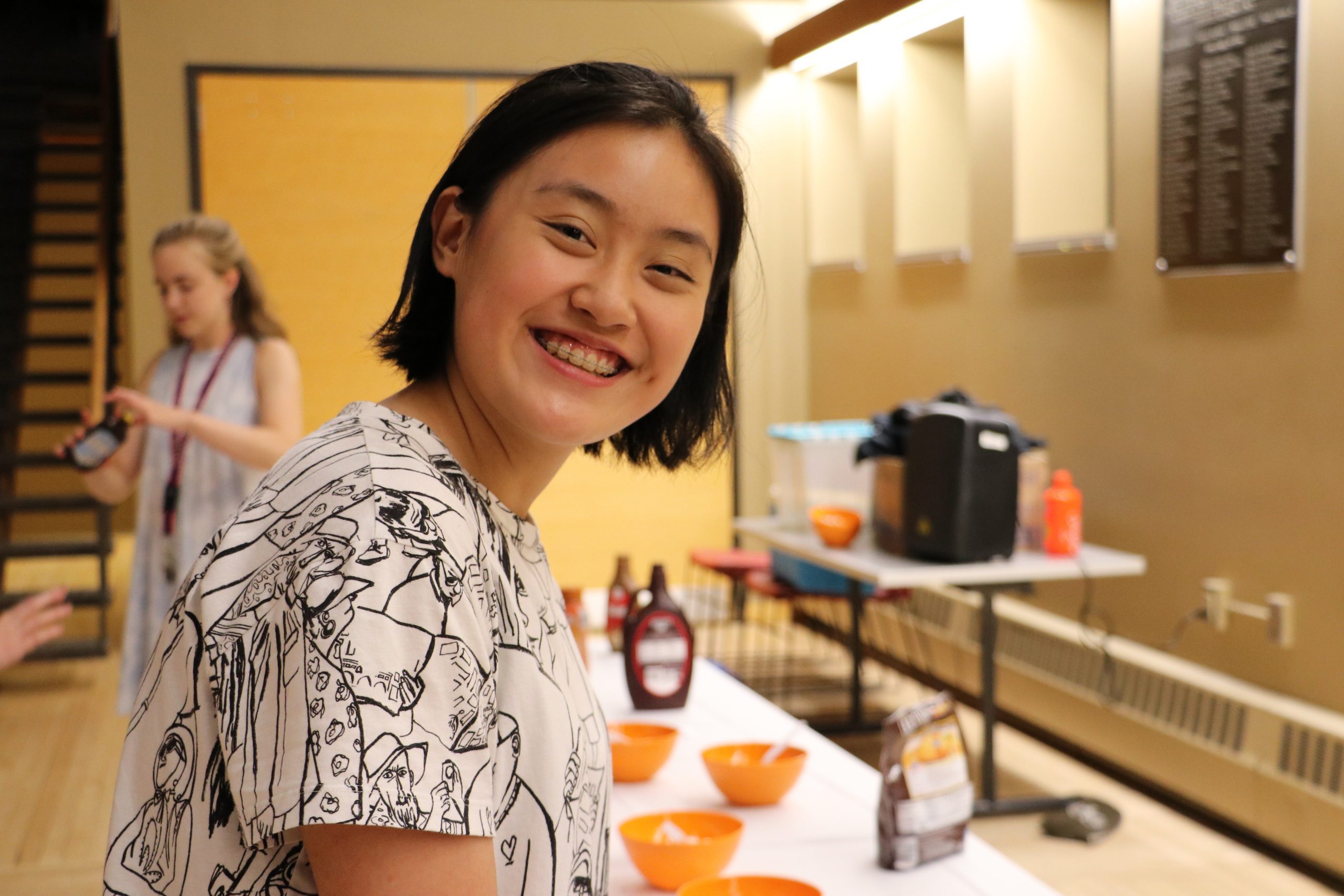 Student smiling at the camera while going through the ice cream sundae line
